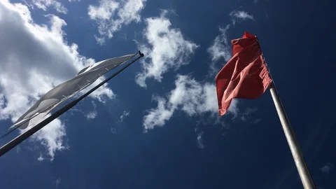 Red, Blue and White flags against the clear blue sky. Optical Flare. Handheld  Stock Footage 109422728