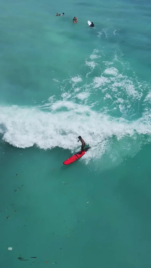 Red Board Slices Through Ocean Water. Sunlit Spray Erupts As Surfer Maneuvers 스톡 동영상 332873030