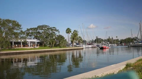 Red Boat and Small Dinghy on Waterfront with Marina and Palm Trees. Editorial Us Stock Footage 315908650