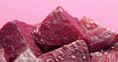 Red boiled beetroot cut into pieces rotates on pink background Stock Footage 320733005