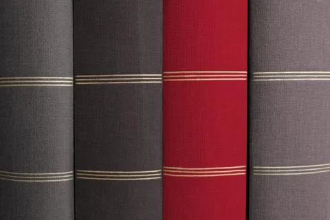 Red book cover in stack of grey books - Stock Photos