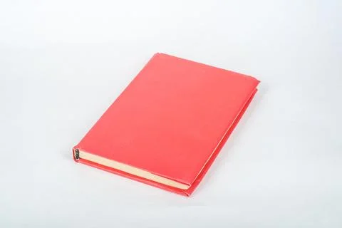 Red book on a white table. Copy space for text. Stock Photos