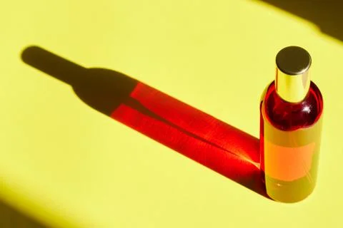 Red bottle with shadow effect isolated on a yellow background. The concept of Stock Photos