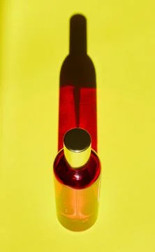 Red bottle with shadow effect isolated on a yellow background. The concept of Stock Photos