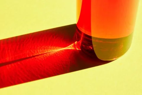 Red bottle with shadow effect isolated on a yellow background. The concept of Stock Photos