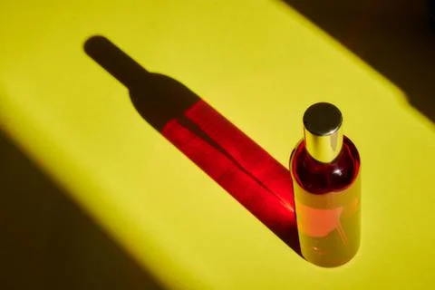 Red bottle with shadow effect isolated on a yellow background. The concept of Stock Photos