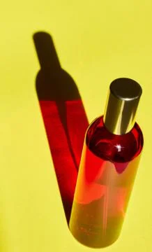 Red bottle with shadow effect isolated on a yellow background. The concept of Stock Photos