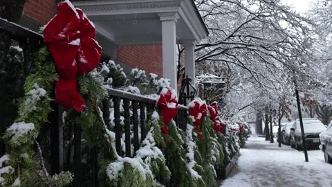 Red bow on fence along snow covered sidewalk in Carroll Gardens Brooklyn Stock Footage 323634286