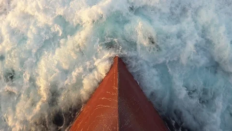Red bow of a modern vessel cuts foamy sea water at sunset Stock Footage 117109623