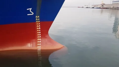 Red bow of the ship in calm weather. A blue ship is moored to the shore in the Stock Footage 149487357