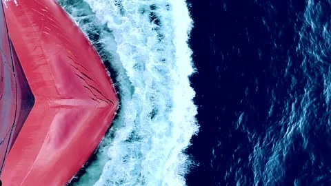 The red bow of a ship cutting through the waves of the sea in a time-lapse video Stock Footage 277395313