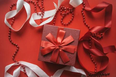 Red box with a gift on a festive background. Stock Photos
