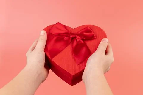 Red box in shape of heart. Gift box for Valentine's Day in the kids hands. Is Stock Photos
