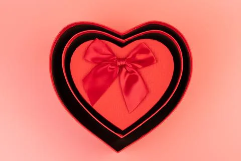 Red box in shape of heart. Gift box for Valentine's Day. Isolated on pink bac Stock Photos