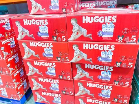 Red boxes of Huggies Plus Little Movers diapers stacked on a store shelf - Fe Fotos Stock
