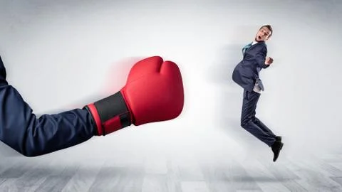 Red boxing glove knocks out little businessman Stock Photos