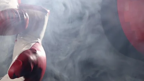 Red Boxing Gloves and Double end striking bag hang in surrounded by smoke. Stock Footage 166605165