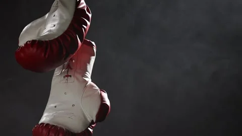 Red Boxing Gloves hang in surrounded by smoke. Stock Footage 166605075
