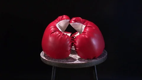 Red boxing gloves rotating on round stool. Stock Footage 73672330