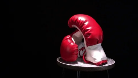 Red boxing gloves rotating on round stool. Stock Footage 73750573