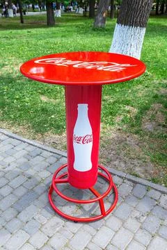 Red branded table of the Coca-Cola company with logo Stock Photos