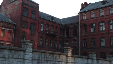 A red brick abandoned building, windows are broken here and there Video stock 152985995