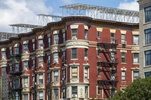 A red brick apartment building features ornate stone carvings Stock Photos