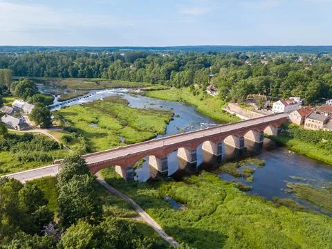 Red brick bridge over Venta river in Kuldiga, Latvia. Stock Photos