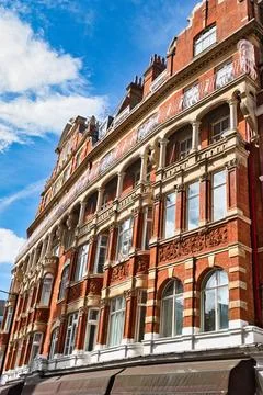 Red brick building with arched windows and decorative elements under blue s.. Stockfoto's