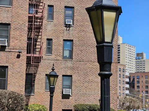 Red brick building with fire escape and lampposts Stock Photos