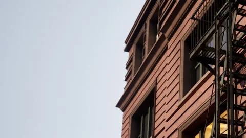 Red Brick Building With Intricate Architecture and Metal Fire Escape Stock Footage 344950681
