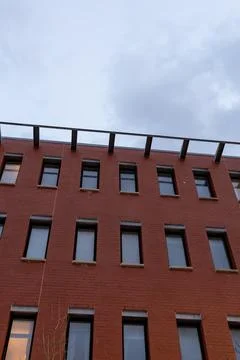 Red brick building with many windows and a clear sky in the late afternoon Fotos Stock