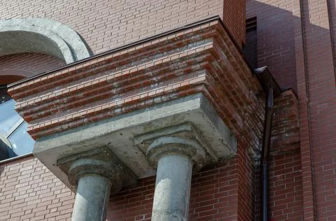 Red brick building with two gray columns. Concrete columns. Drainpipe. Constr Stock Photos