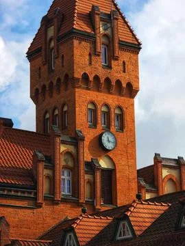 Red brick clock tower with tiled roofs Stock Photos