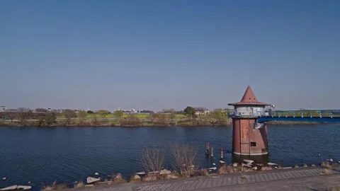 Red Brick Conical Water Tower at Wide River Edge with Spring Green Bank, Japan Stock Footage 337975257