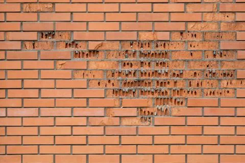 Red brick crumbles in the wall. The facing brick crumbles. Destruction of bri Stock-Fotos