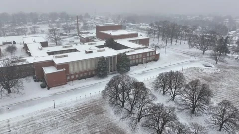 Red brick high school in rural countryside of snowy American town. Aerial Vídeos de archivo 303880690