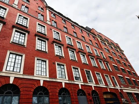 Red brick industrial building faade in Manchester, UK with rows of tall win.. Stock Photos