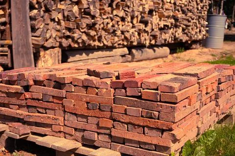 Red brick packed in stack are stored on ground outdoors at a hardware store Stock Photos