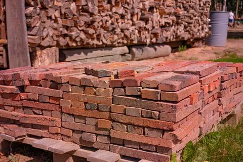 Red brick packed in stack are stored on ground outdoors at a hardware store Foto stock