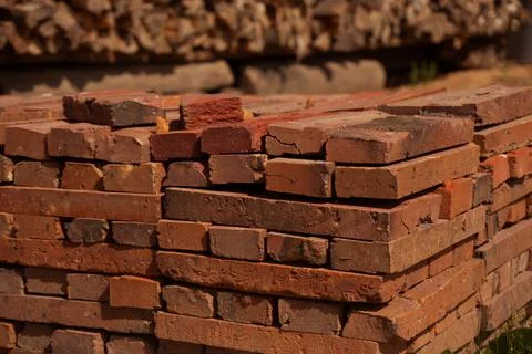 Red brick packed in stack are stored on ground outdoors at a hardware store Foto stock