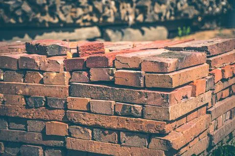 Red brick packed in stack are stored on ground outdoors at a hardware store Foto stock
