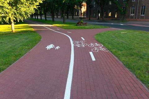 Red brick shared path with pedestrian and bicycle symbols Stock Photos
