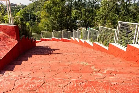 Red Brick Staircase Cutting Through Green Forest Hills Stock Photos