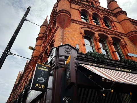 Red brick Victorian pub M J Wright on a corner in Dublin Ireland with ornat.. Stock Photos