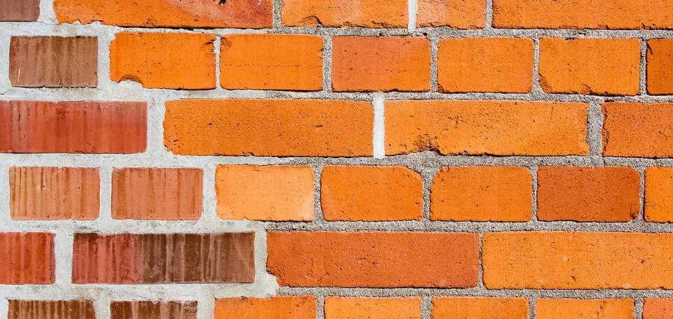 Red brick wall of bricks of different tint Stock Photos
