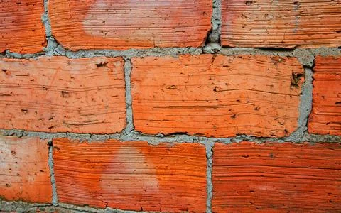 Red brick wall close-up. The texture of an old brick. Uneven, cracked surface Stock Photos