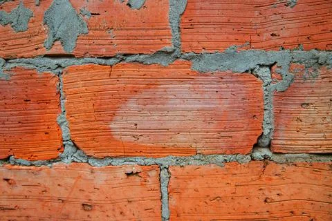 Red brick wall close-up. The texture of an old brick. Uneven, cracked surface Stock Photos