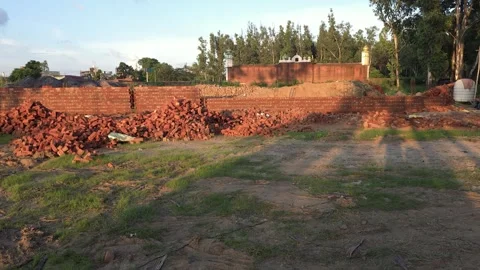 Red brick wall construction site with building materials in an open field Vídeos de archivo 347256907