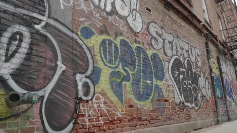 A red brick wall covered in graffiti Stock Footage 241498546